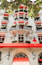 A tall white building with red awnings and windows
