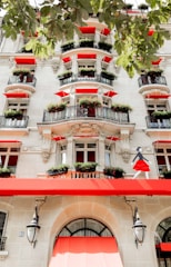 A tall white building with red awnings and windows