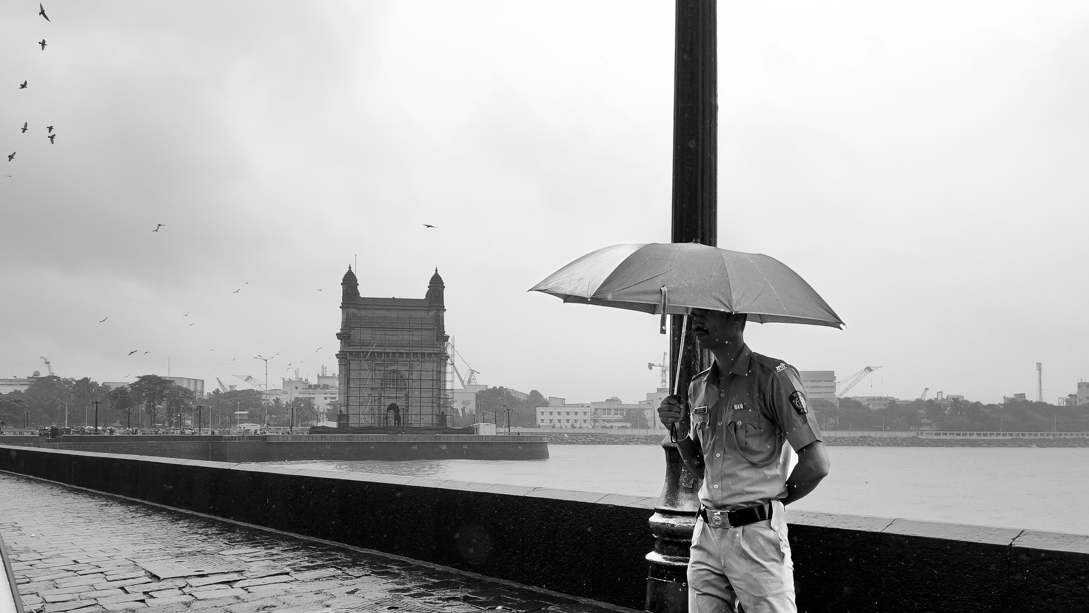 A person standing on a bridge with an umbrella
