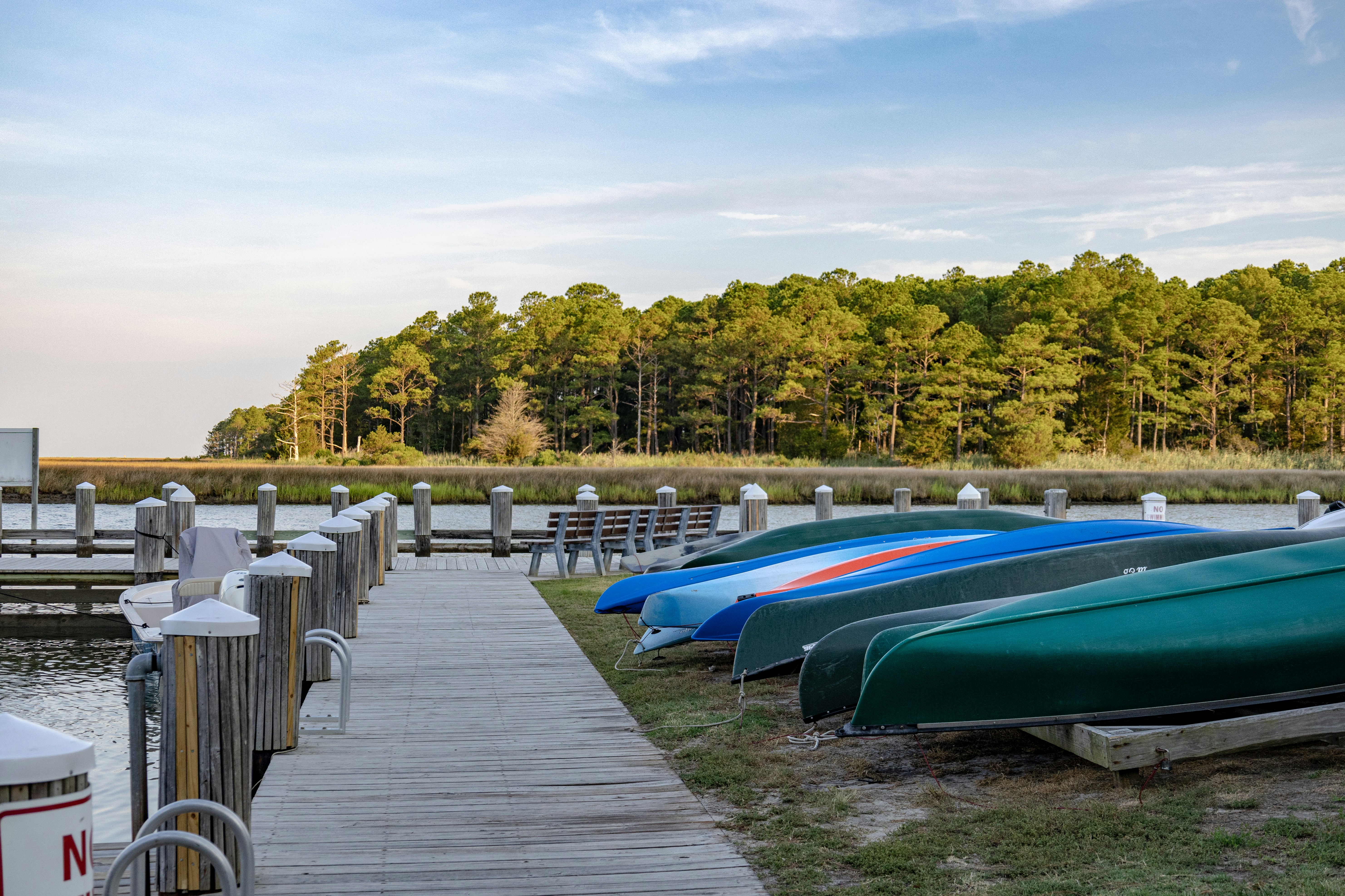 A row of boats sitting on top of a grass covered field