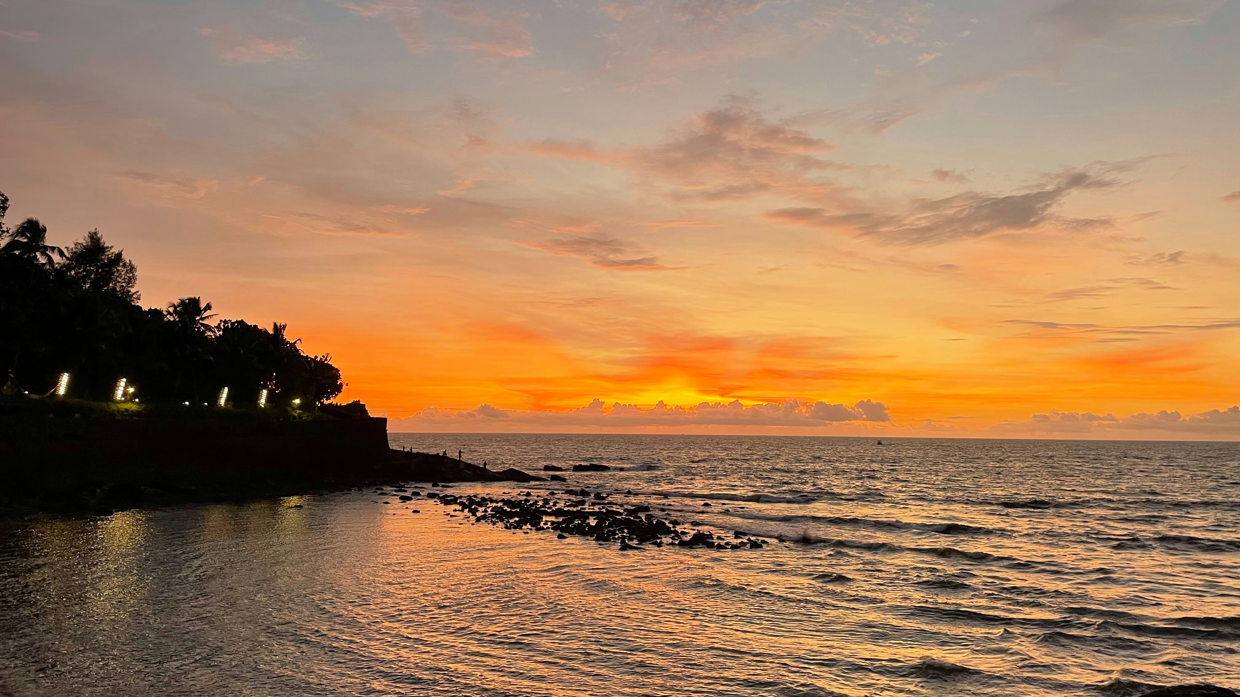 Wide landscape painting with Caribbean horizon, deep turquoise sea meeting vivid orange sky