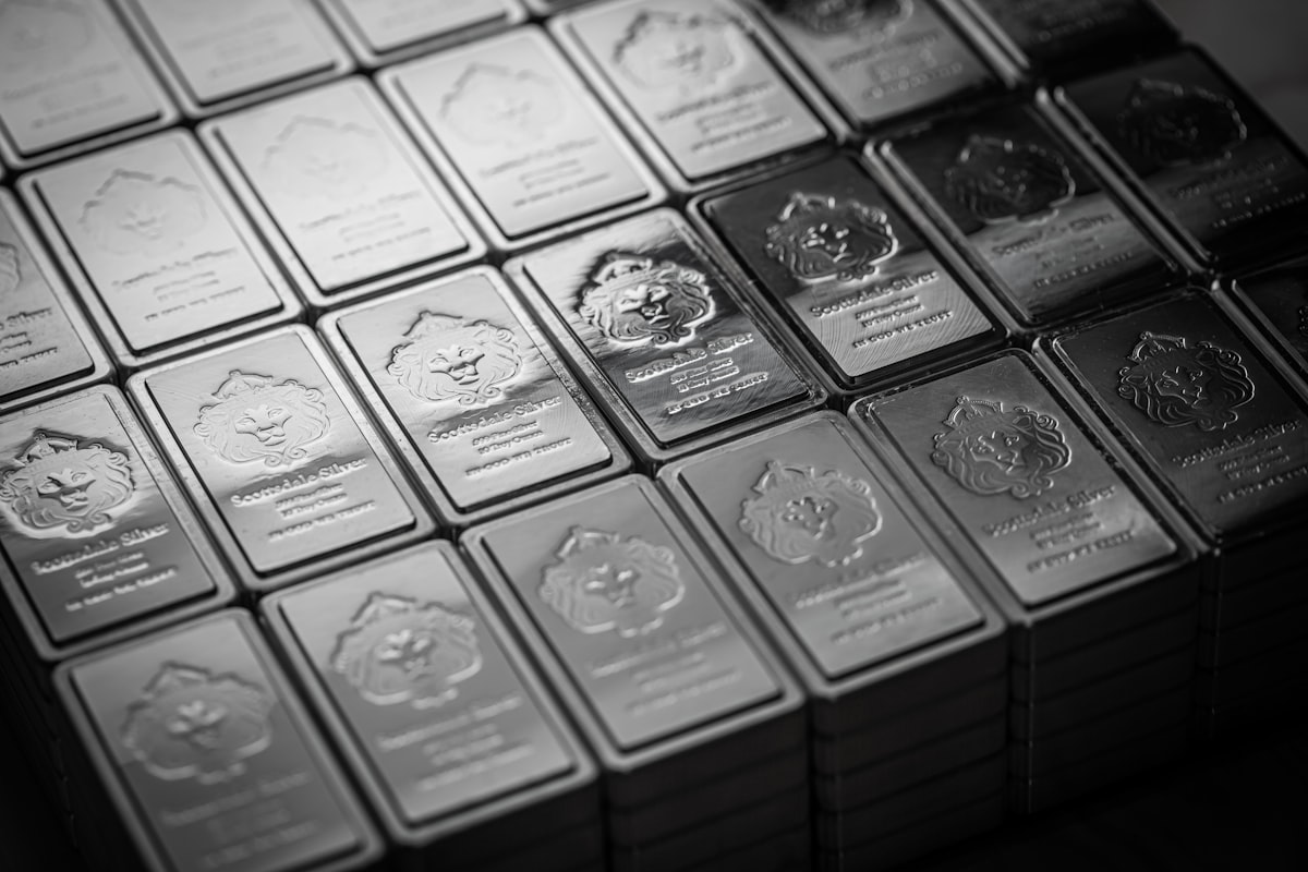 A pile of polished silver bullion bars stacked on a table representing precious metals investment