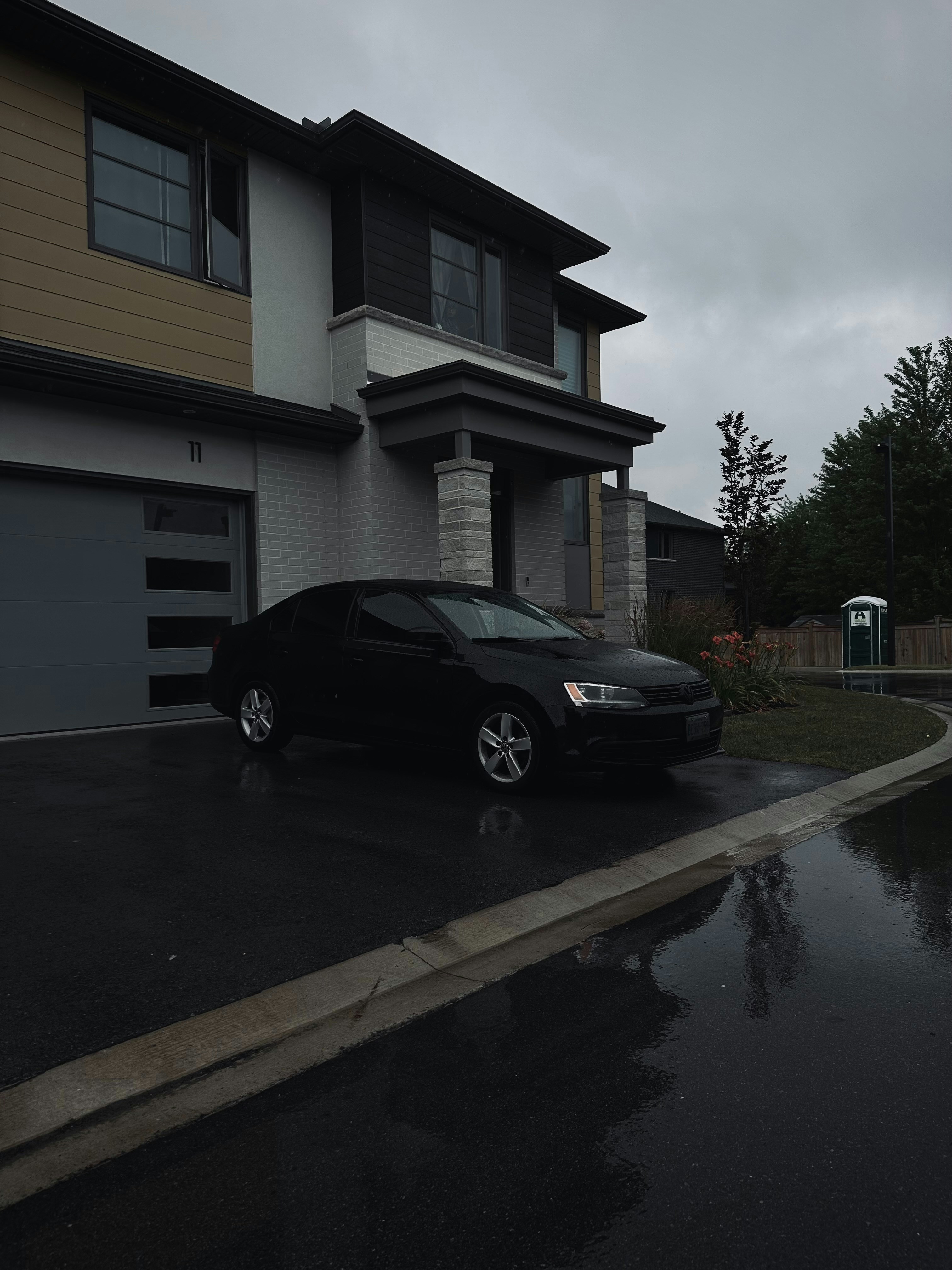 A black car parked in front of a house