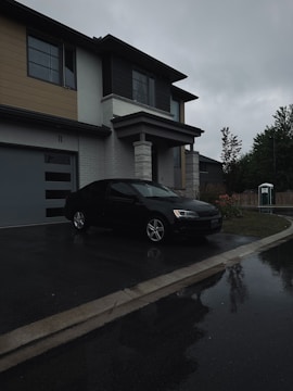 A black car parked in front of a house