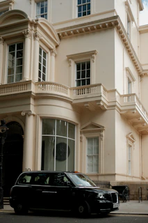 A black car is parked in front of a building