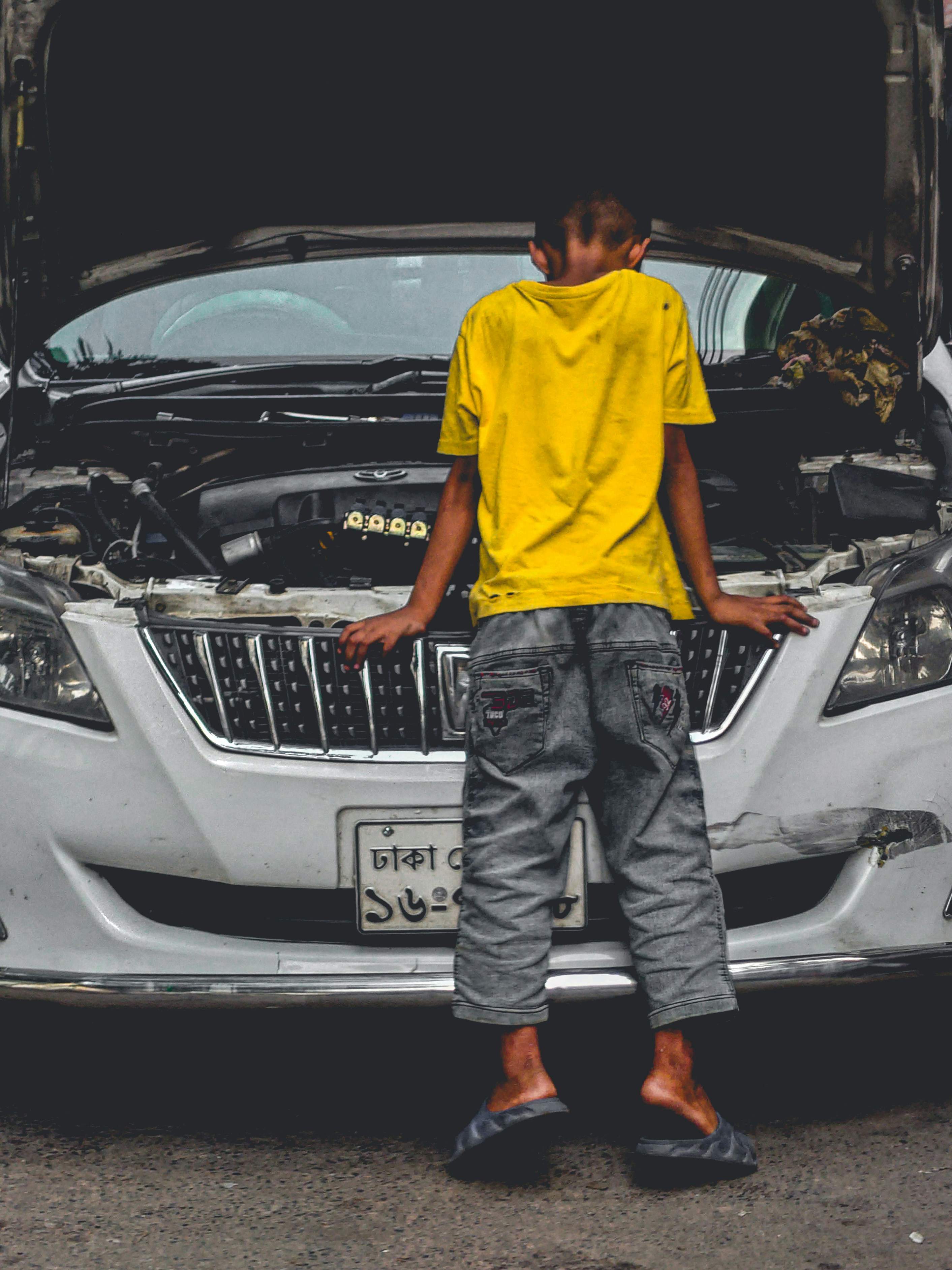 A man standing in front of a car with the hood open