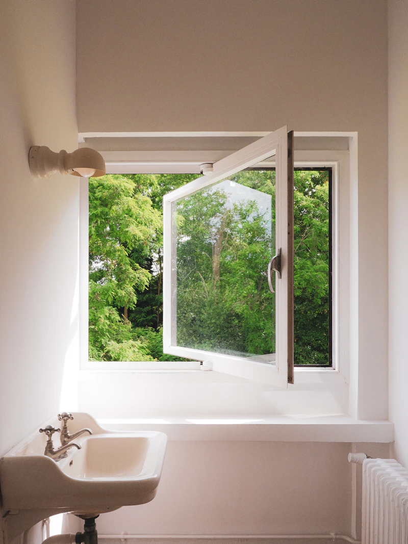 Baño moderno con ventana de aluminio sobre el lavamanos