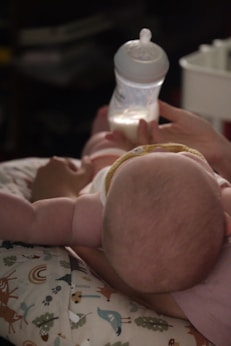 A woman holding a baby while holding a bottle