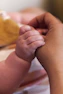 A close up of a person holding a baby's hand