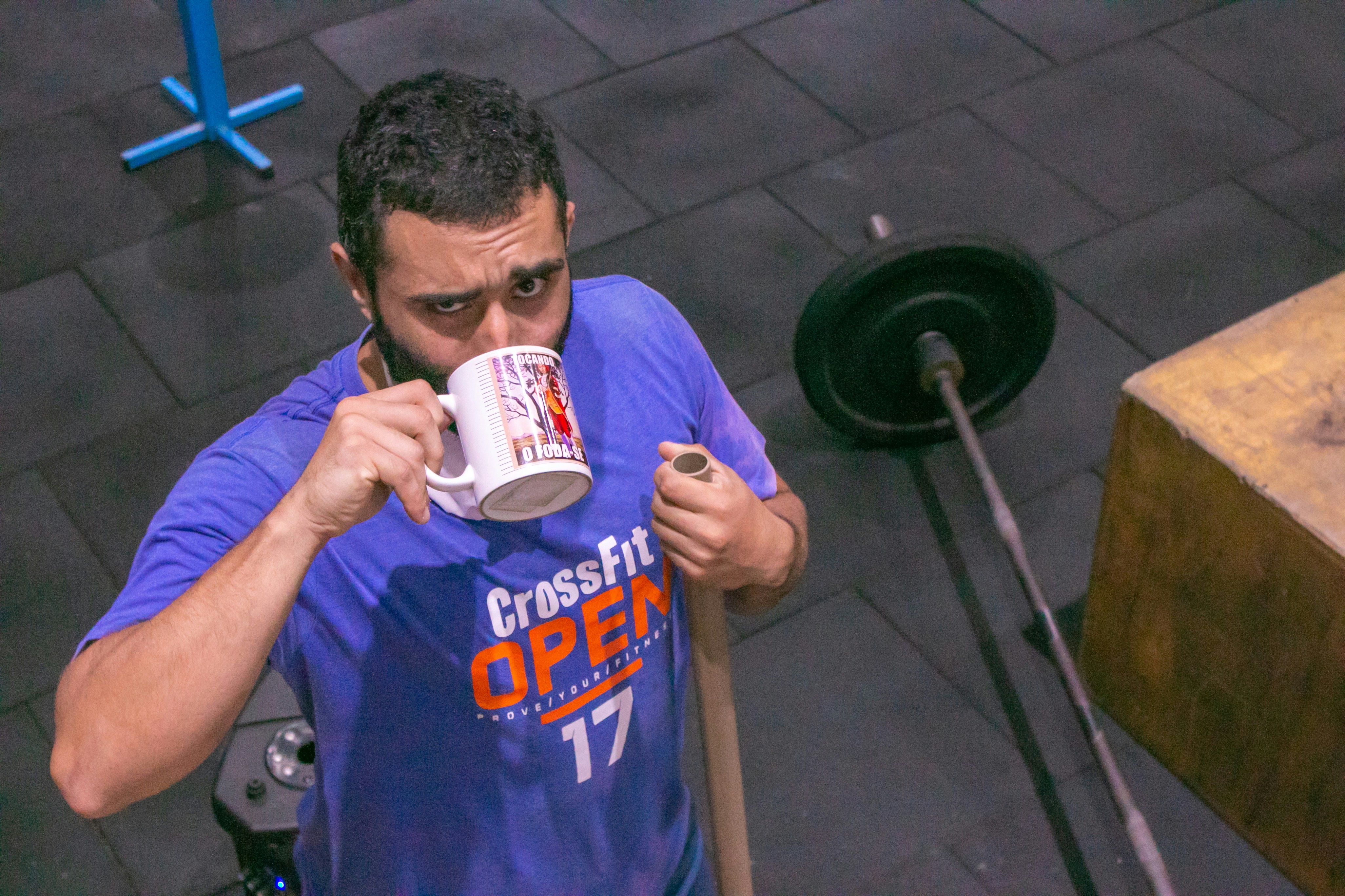Tasse de café posée près d'un équipement de sport, symbolisant la caféine comme aide ergogénique