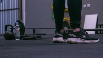 A person standing next to a skateboard on the ground