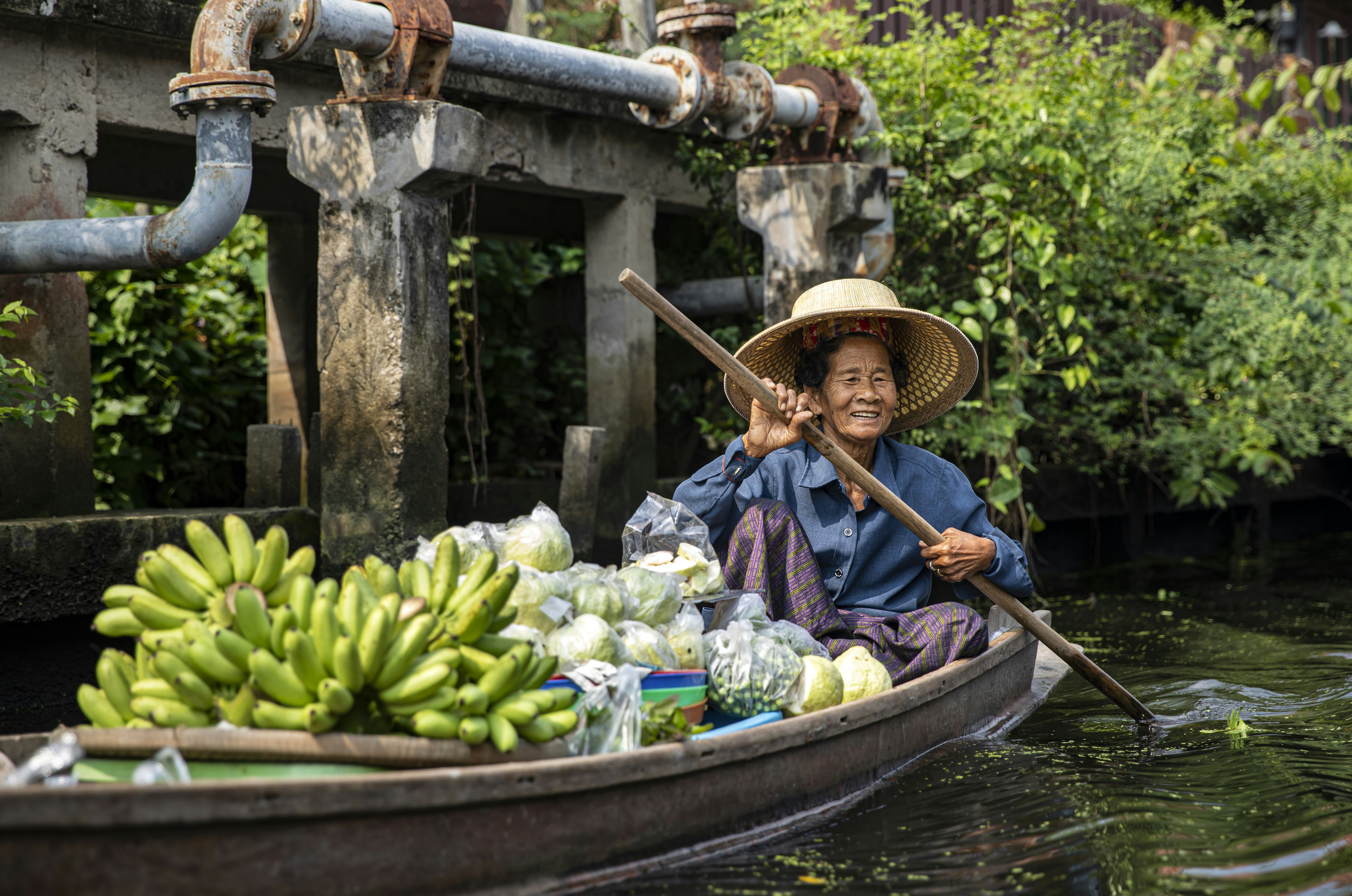 A woman in a boat filled with lots of bananas, 