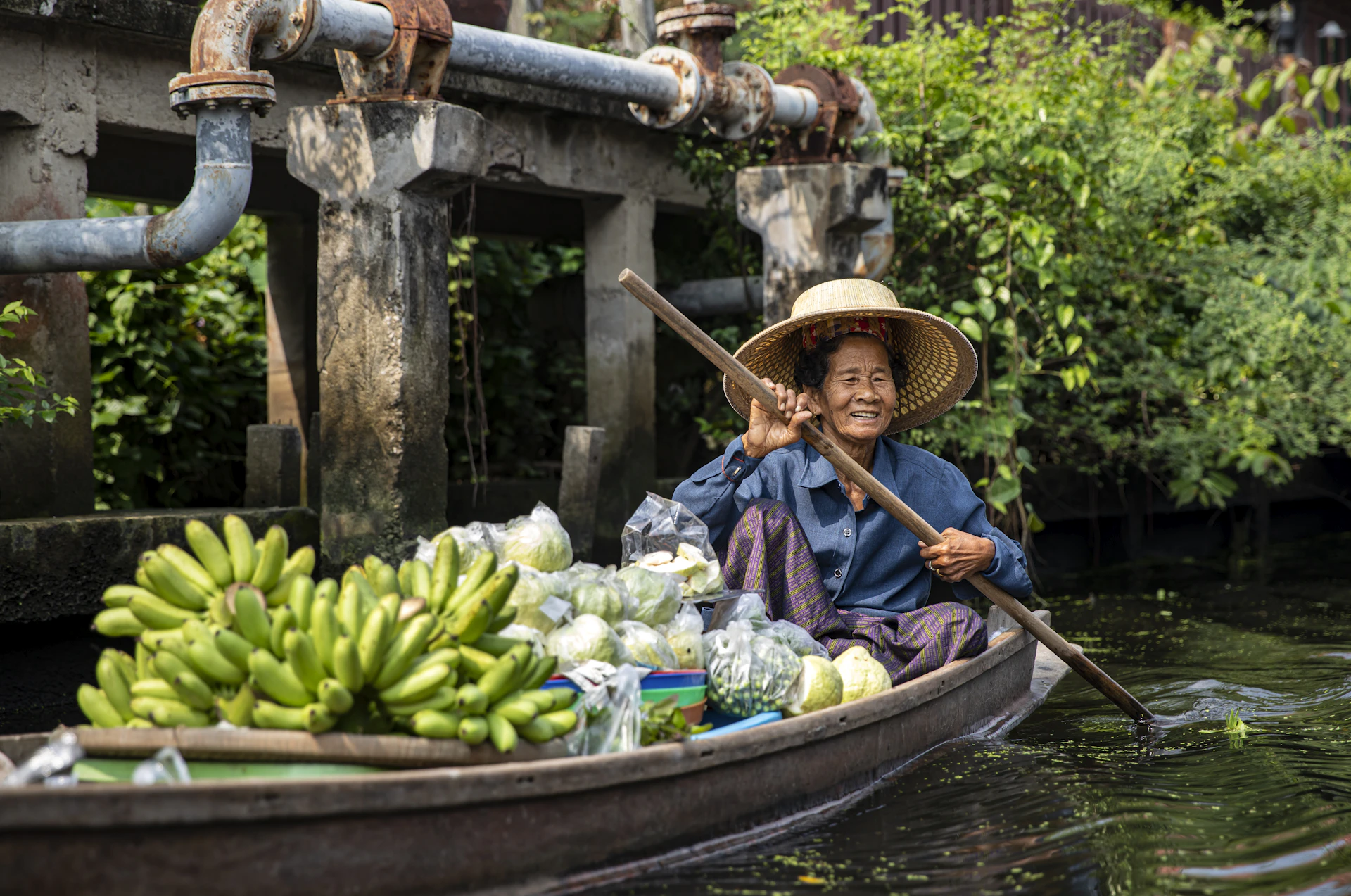 A woman in a boat filled with lots of bananas