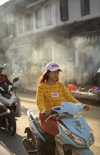 A group of people riding scooters down a street