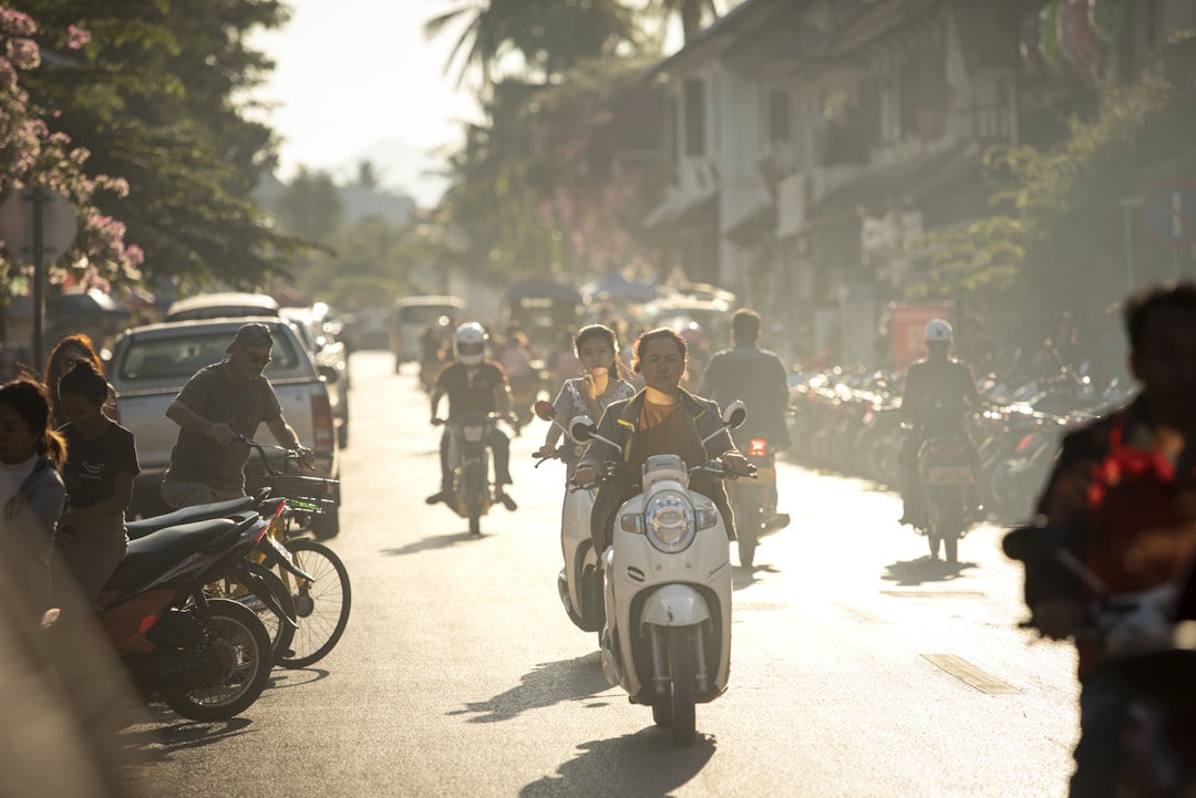 A group of people riding motorcycles down a street,