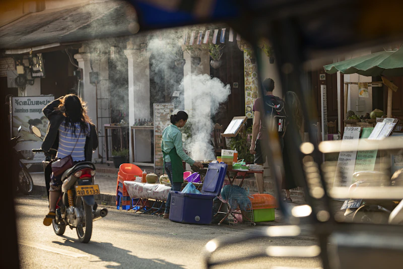 A man riding a bike down a street next to a woman