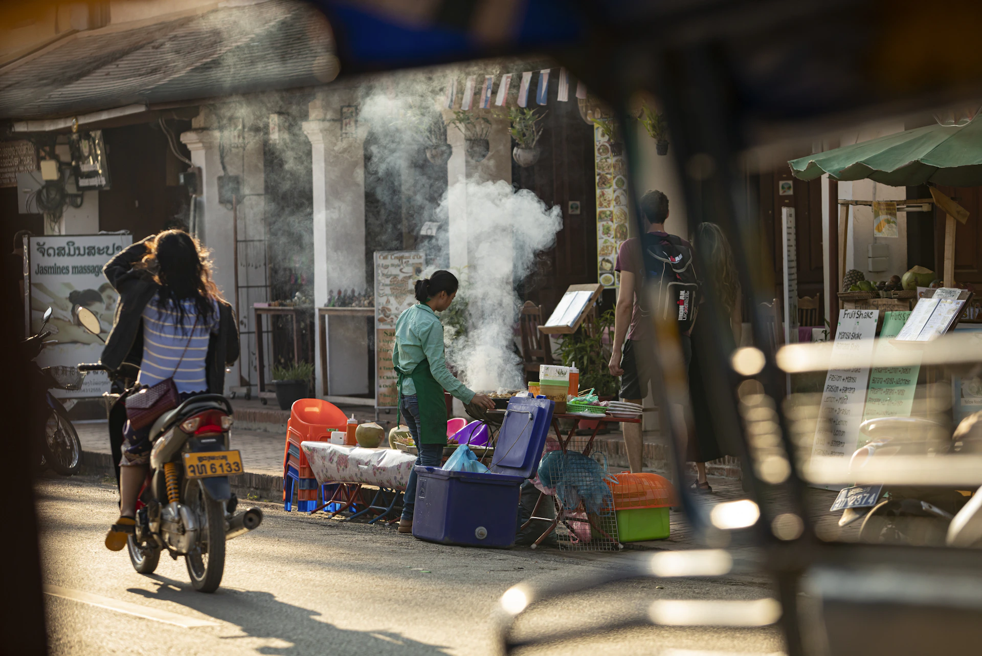 A man riding a bike down a street next to a woman