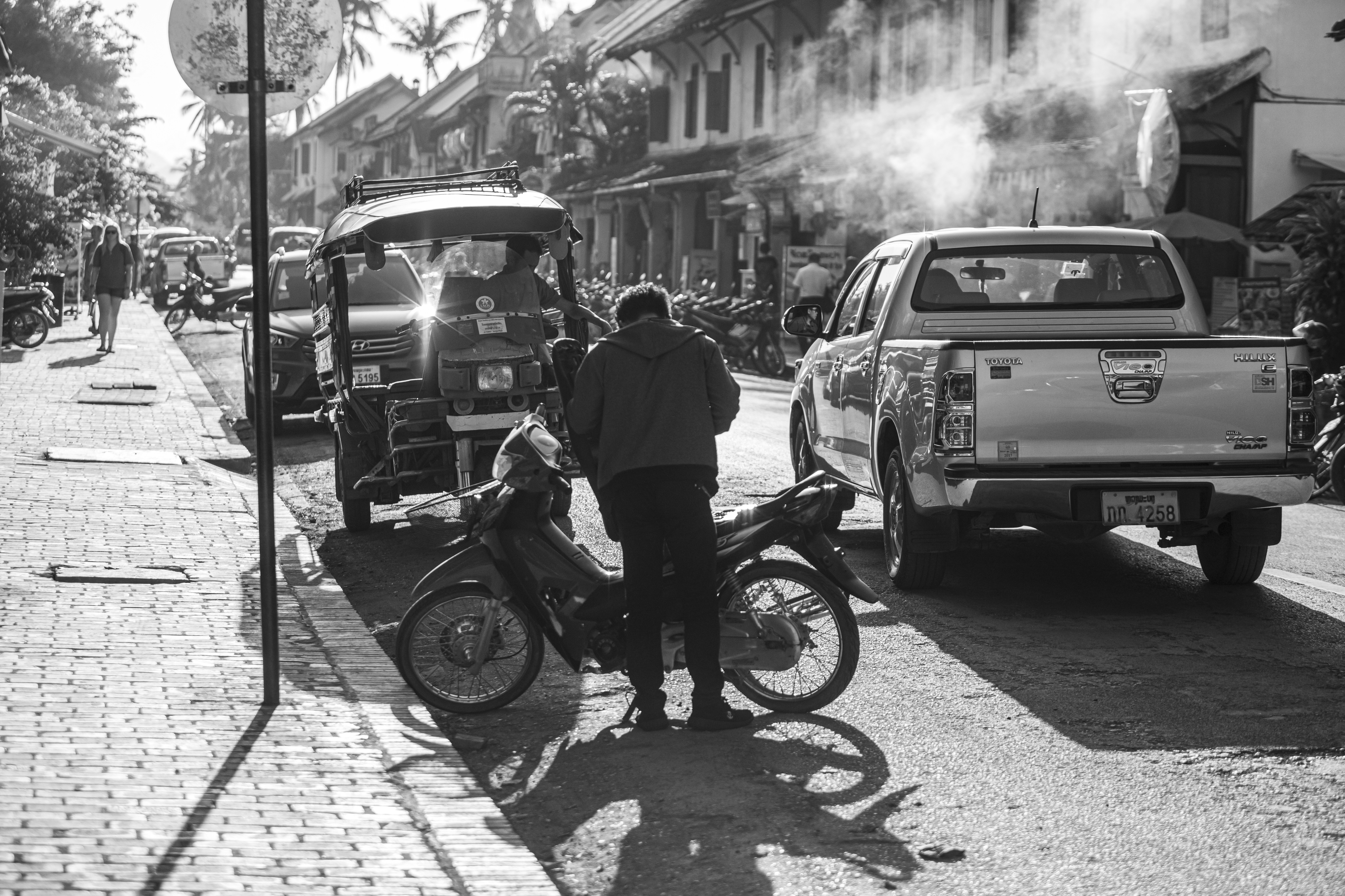 Ein Schwarz-Weiß-Foto eines Mannes, der neben einem Motorrad steht