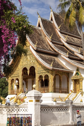 A white and gold building with a tree in the background