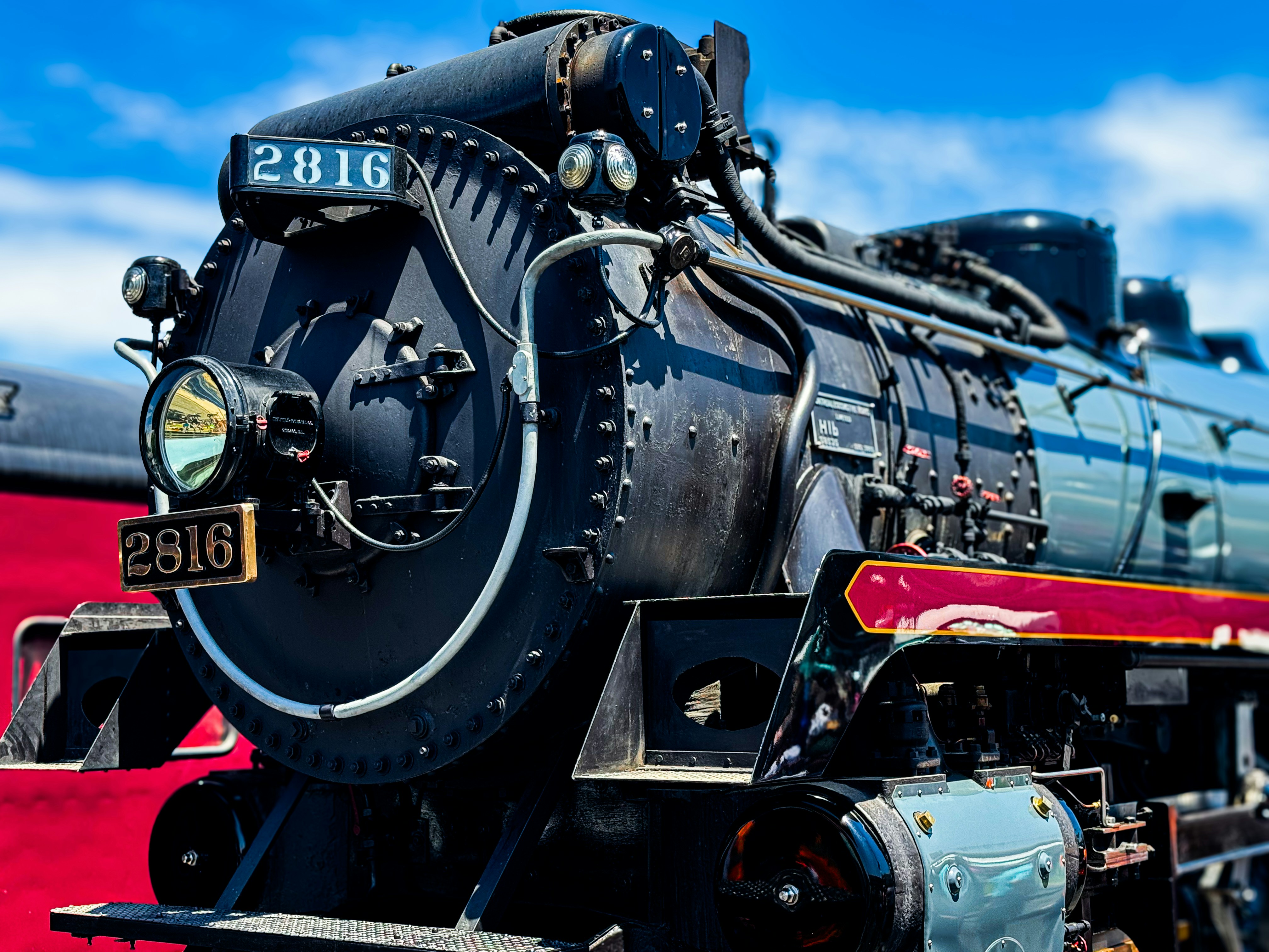 A black train engine sitting next to a red wall photo – Free Train ...