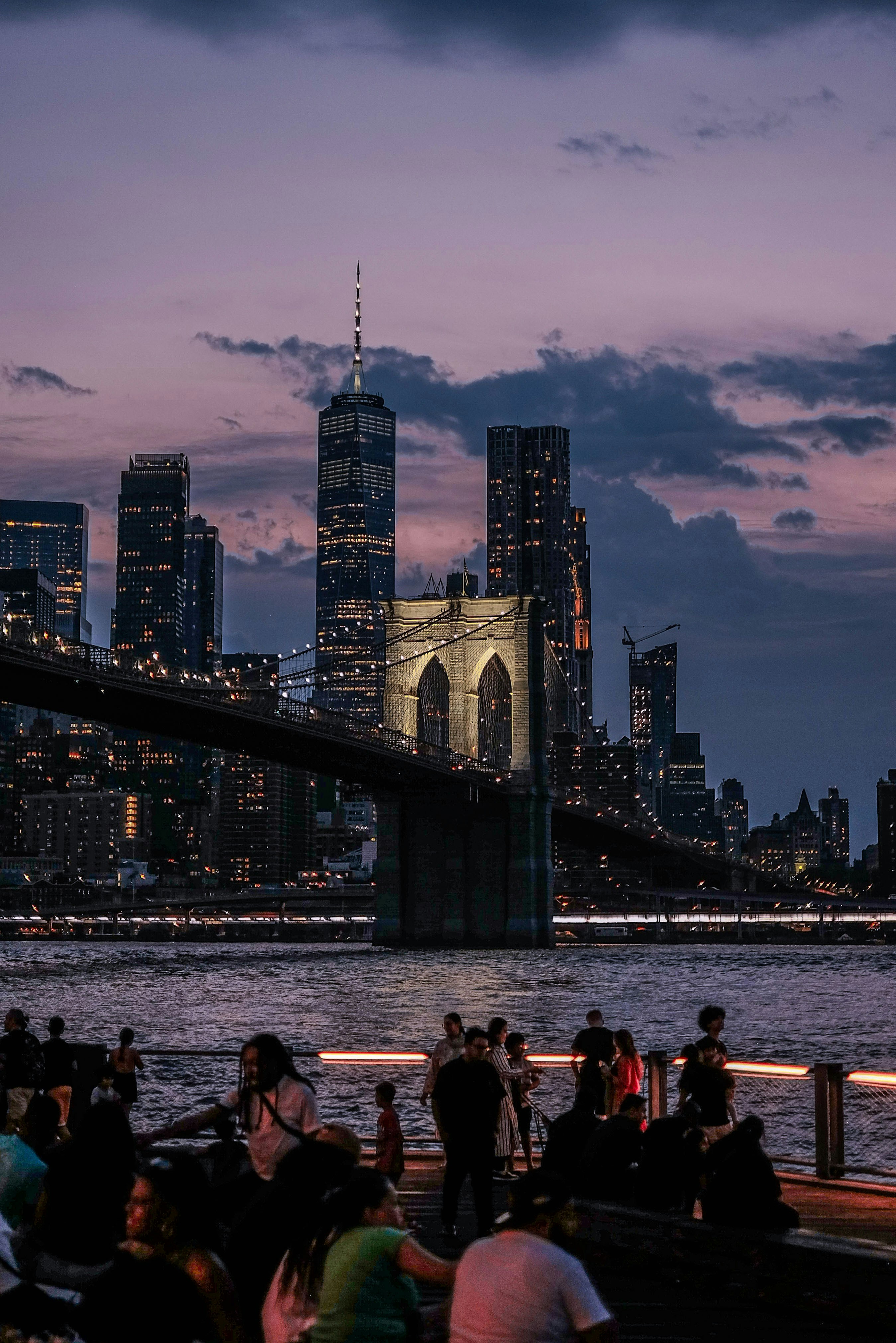 A group of people sitting on a pier next to the water