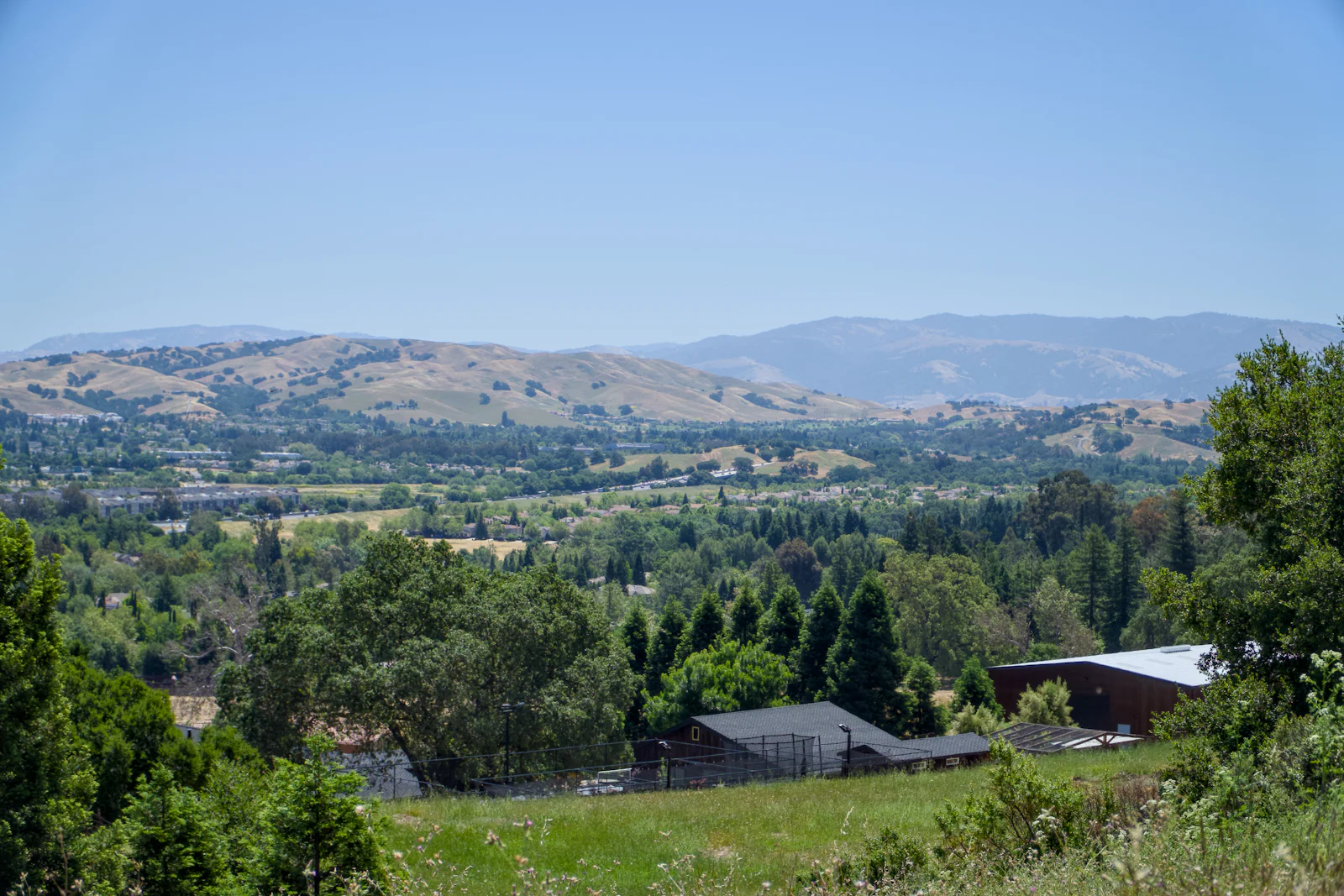 Green Northern California valley with homes and rolling hills, the kind of market where Prop 19 downsizers move