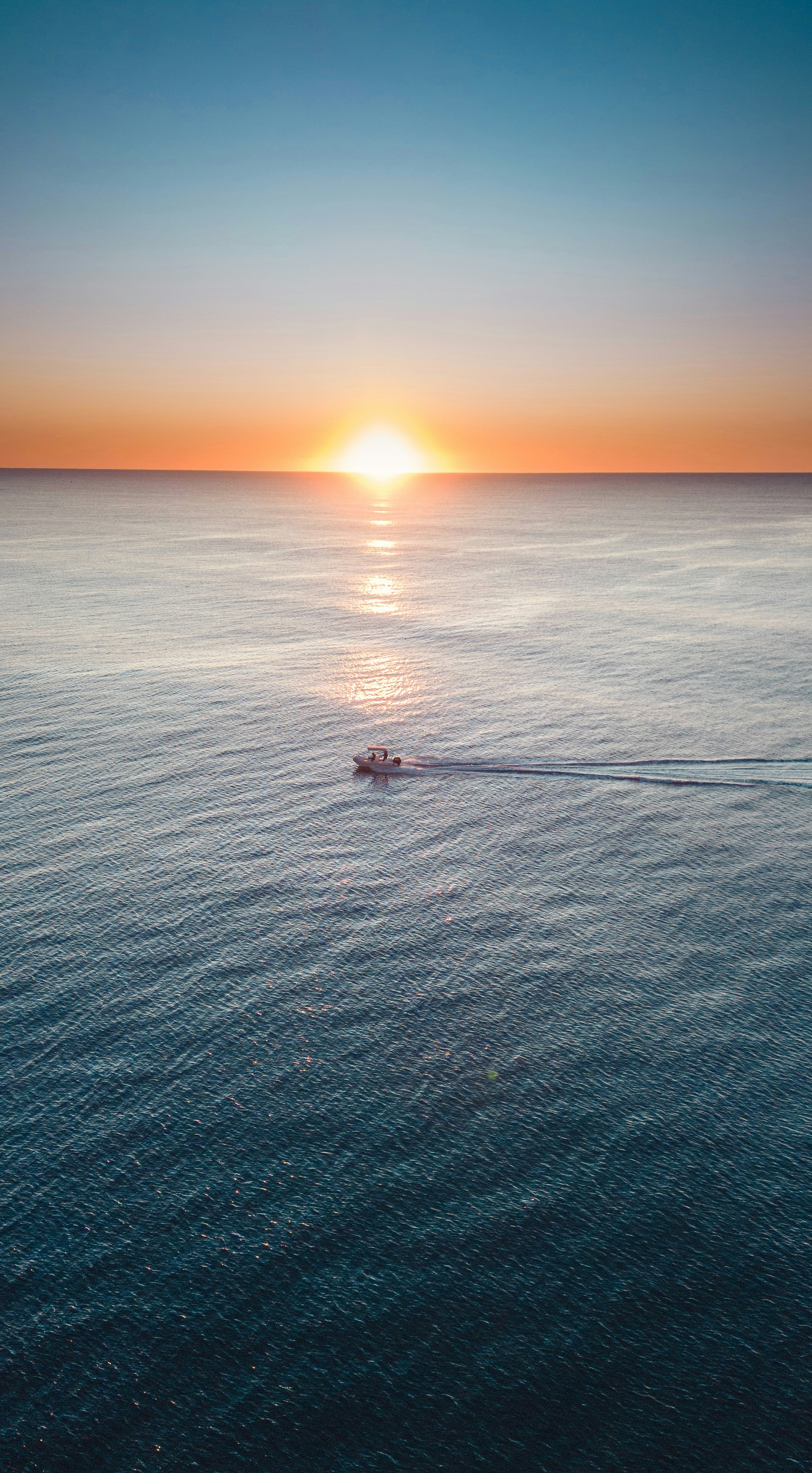 夕暮れ時の海の真ん中に浮かぶボート