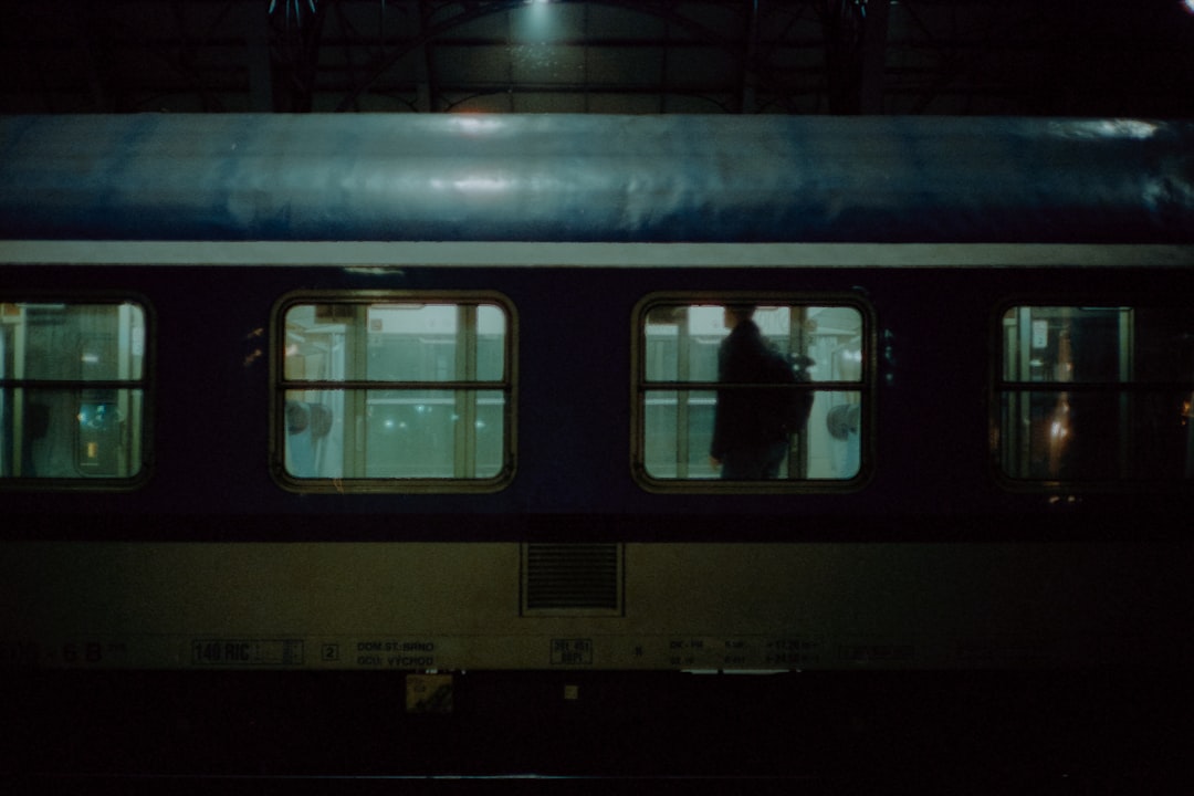 A subway car at night with people standing on it,
