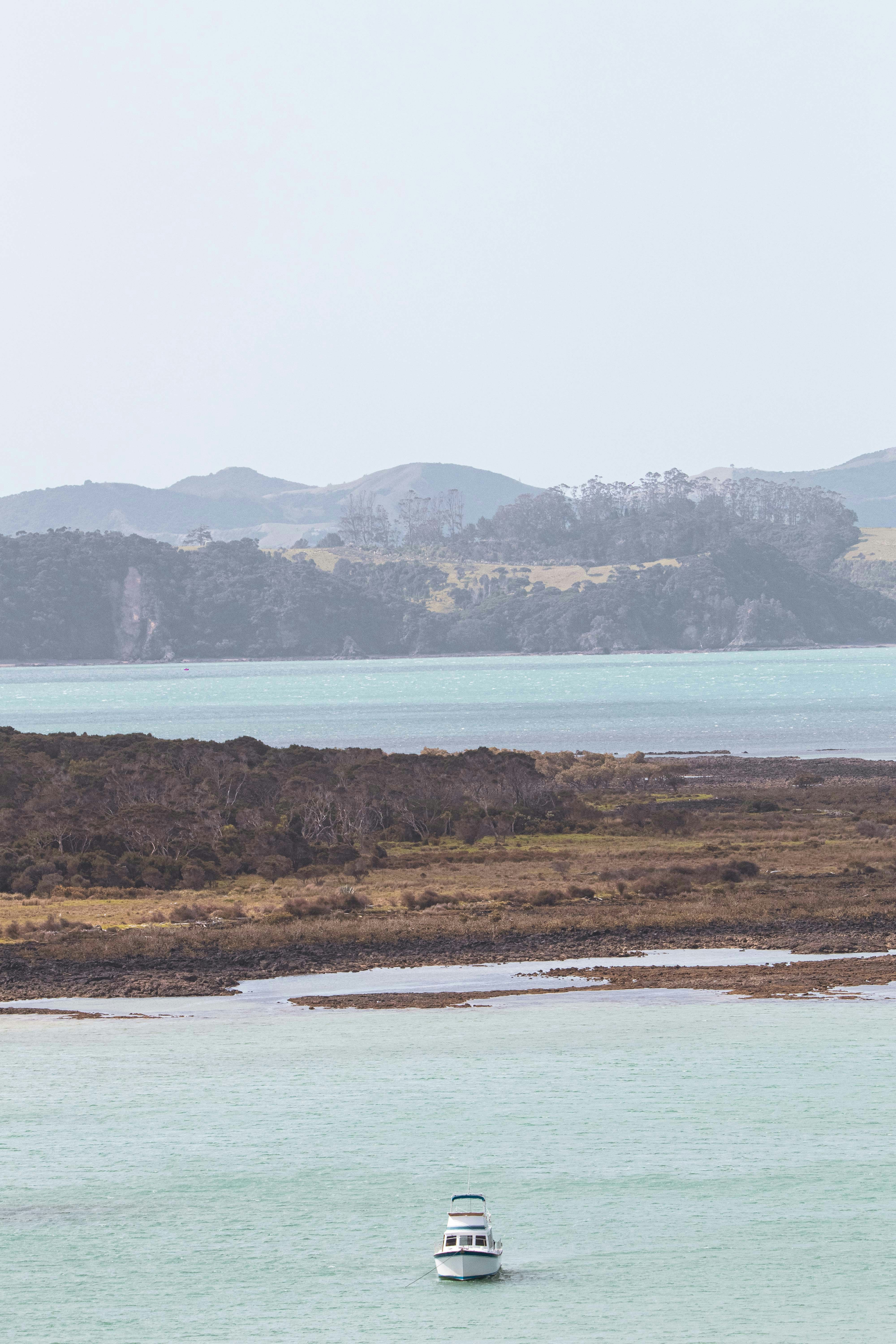 A couple of boats floating on top of a large body of water photo – Free ...