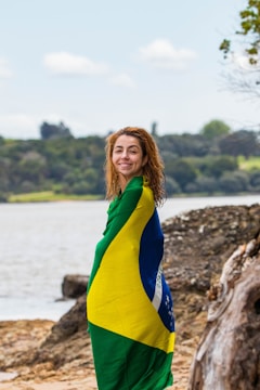 A woman standing on a beach with a towel wrapped around her