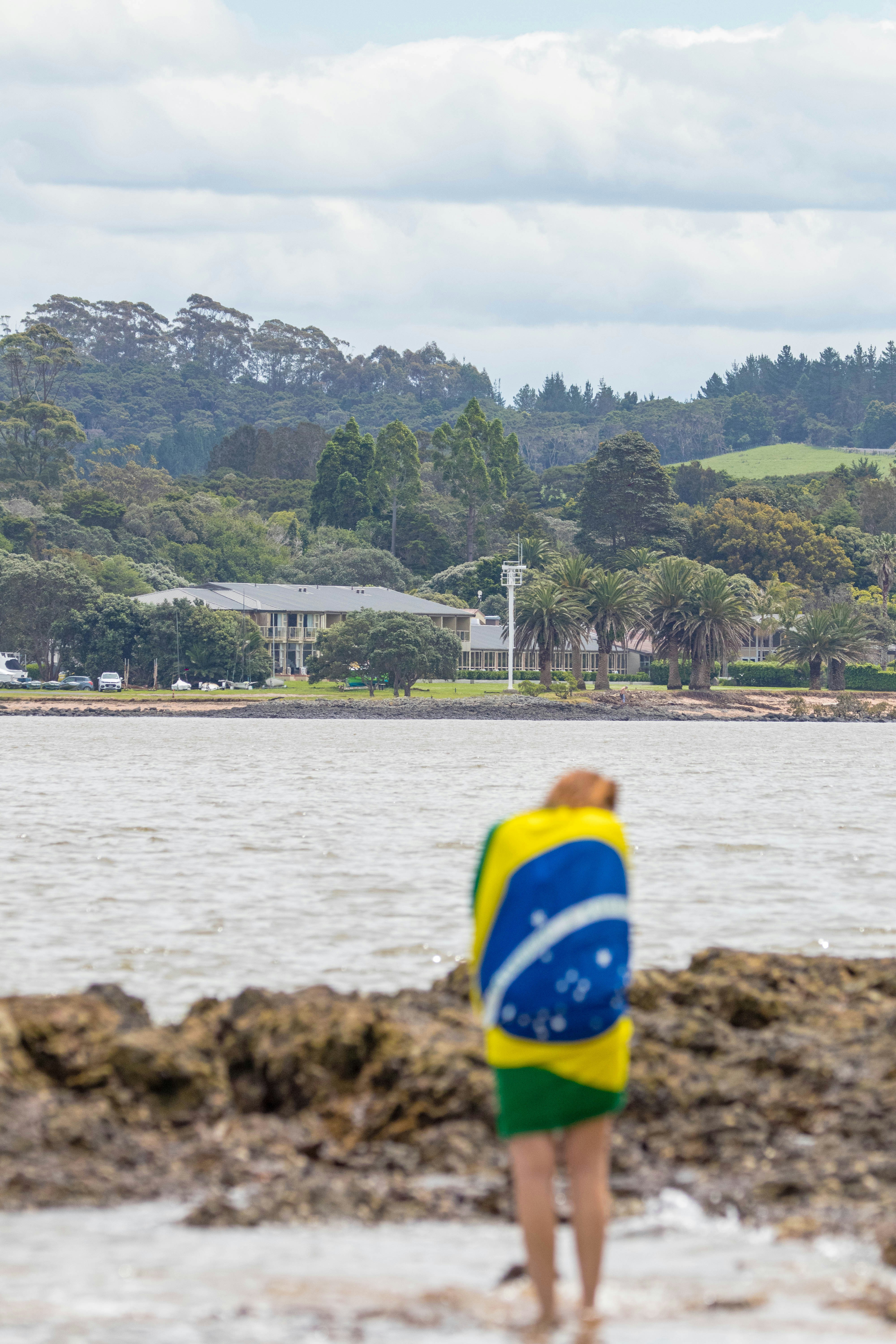 A man standing on top of a beach next to a body of water