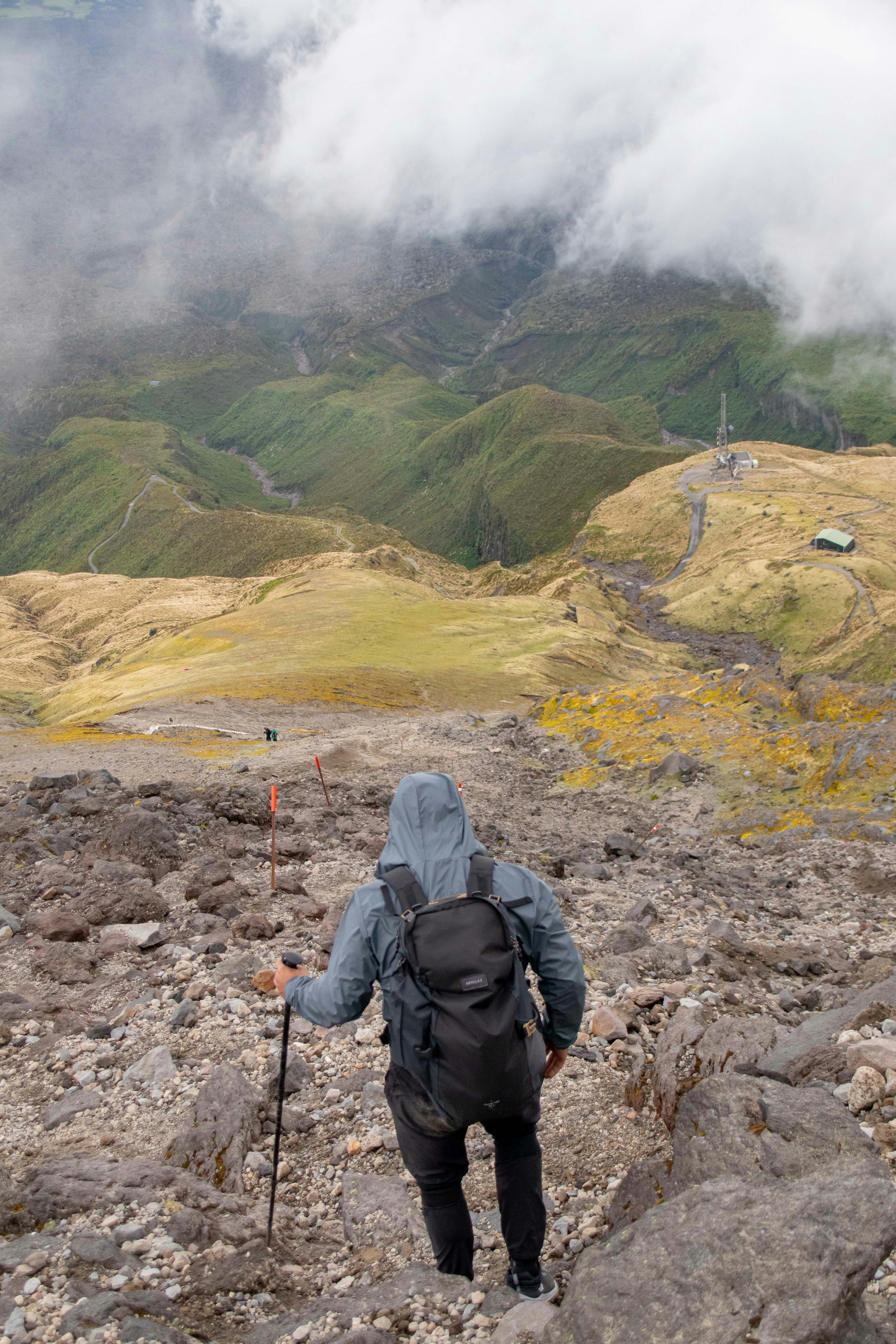 A person with a backpack hiking up a mountain