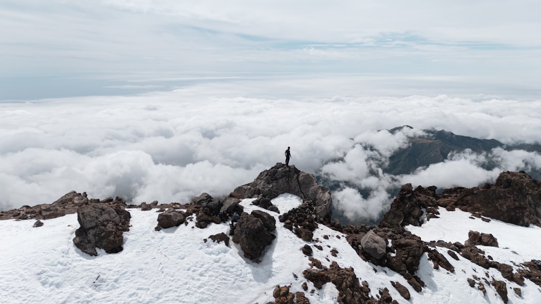 A man standing on top of a snow covered mountain,
