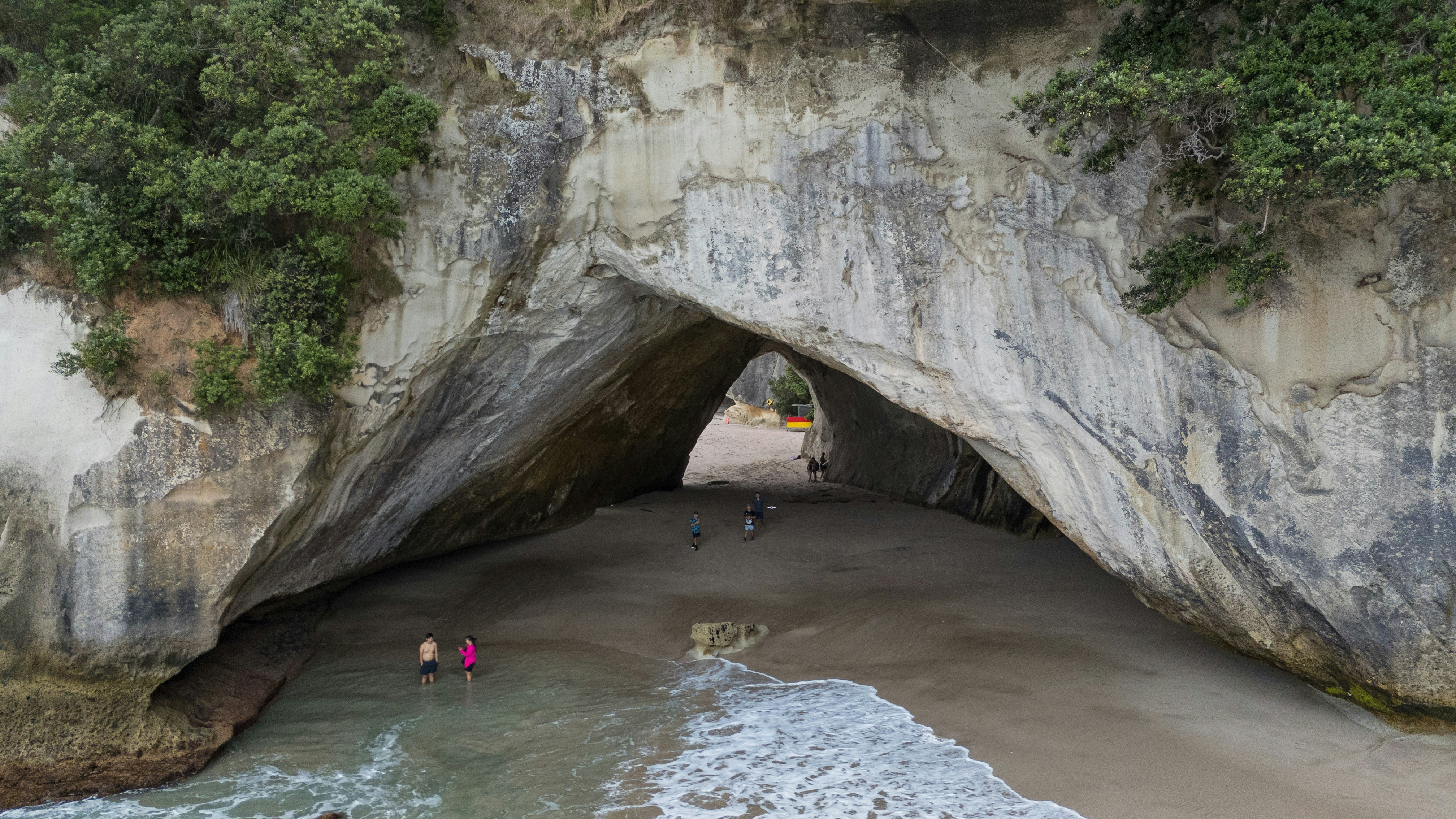 A group of people standing in the entrance to a cave