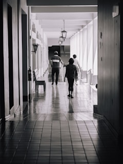 A couple of people that are walking down a hallway