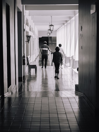 A couple of people that are walking down a hallway