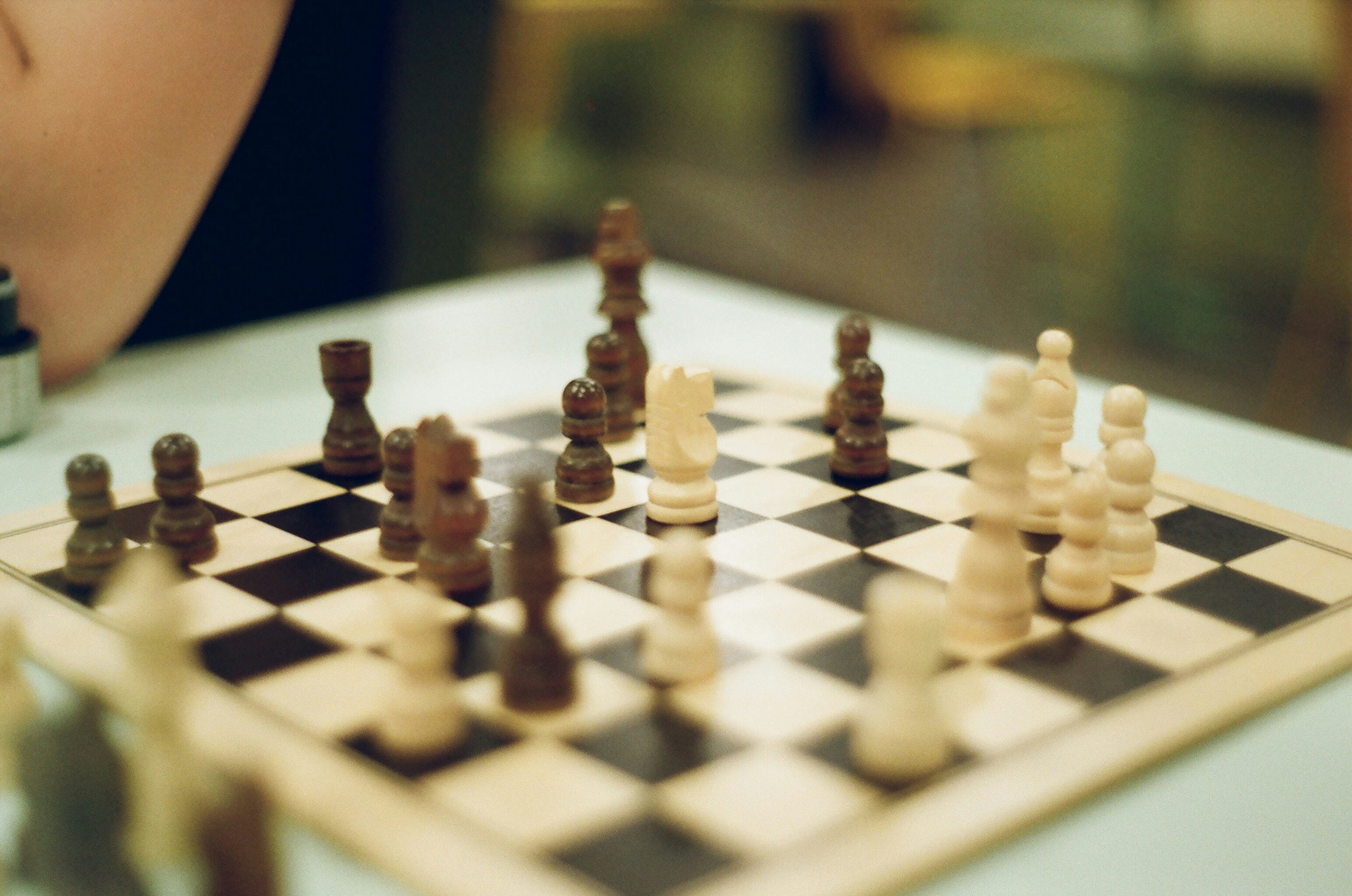A person playing a game of chess on a table