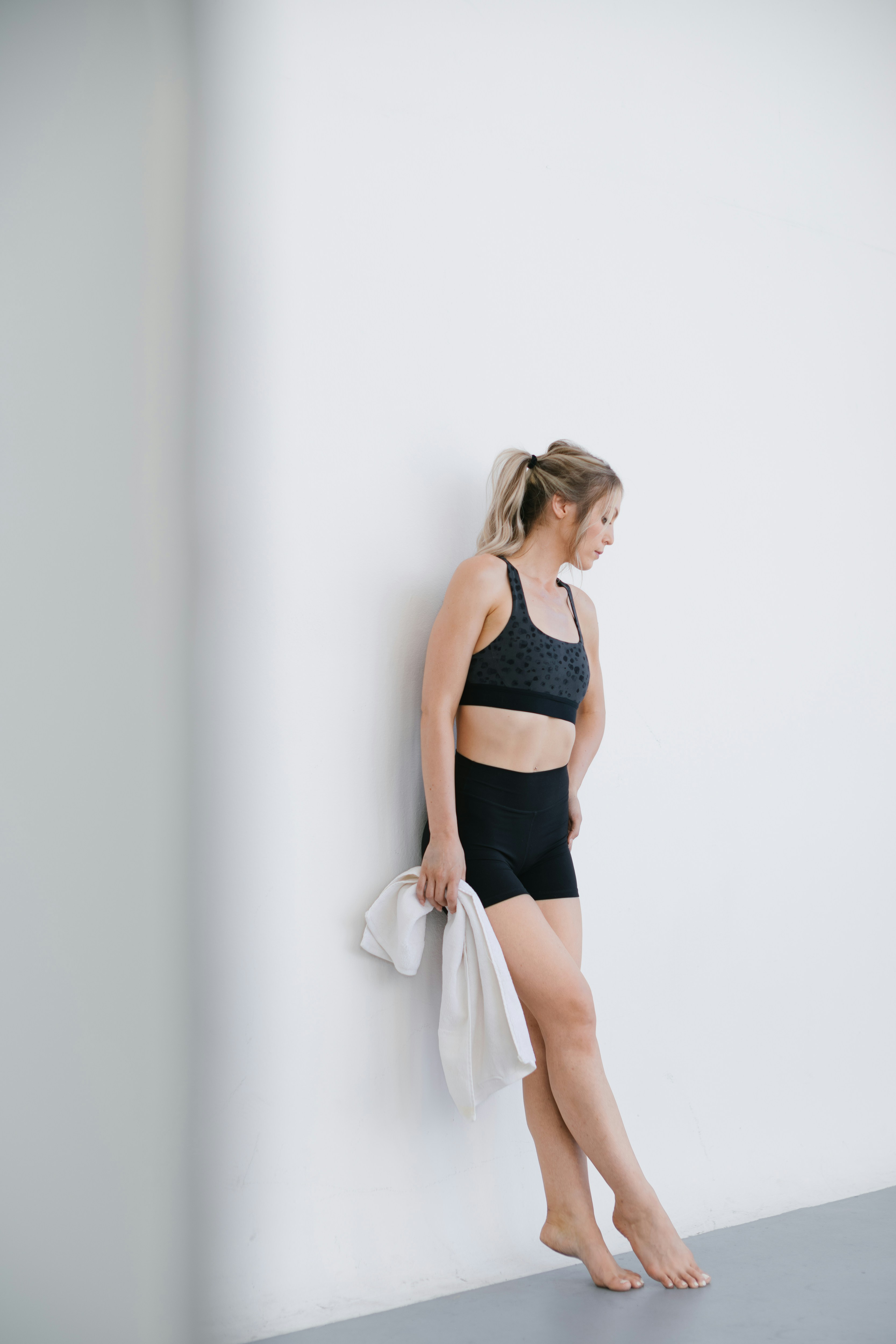 A woman leaning against a wall with a towel