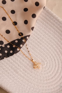 A close up of a polka dot cloth with a necklace on it