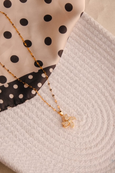 A close up of a polka dot cloth with a necklace on it