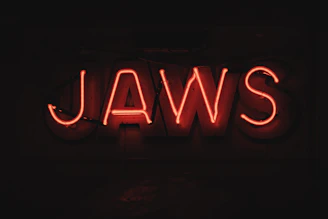 A red neon sign that says jaws
