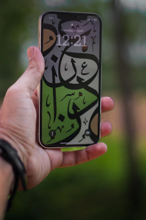 A person holding a cell phone with a painting on it