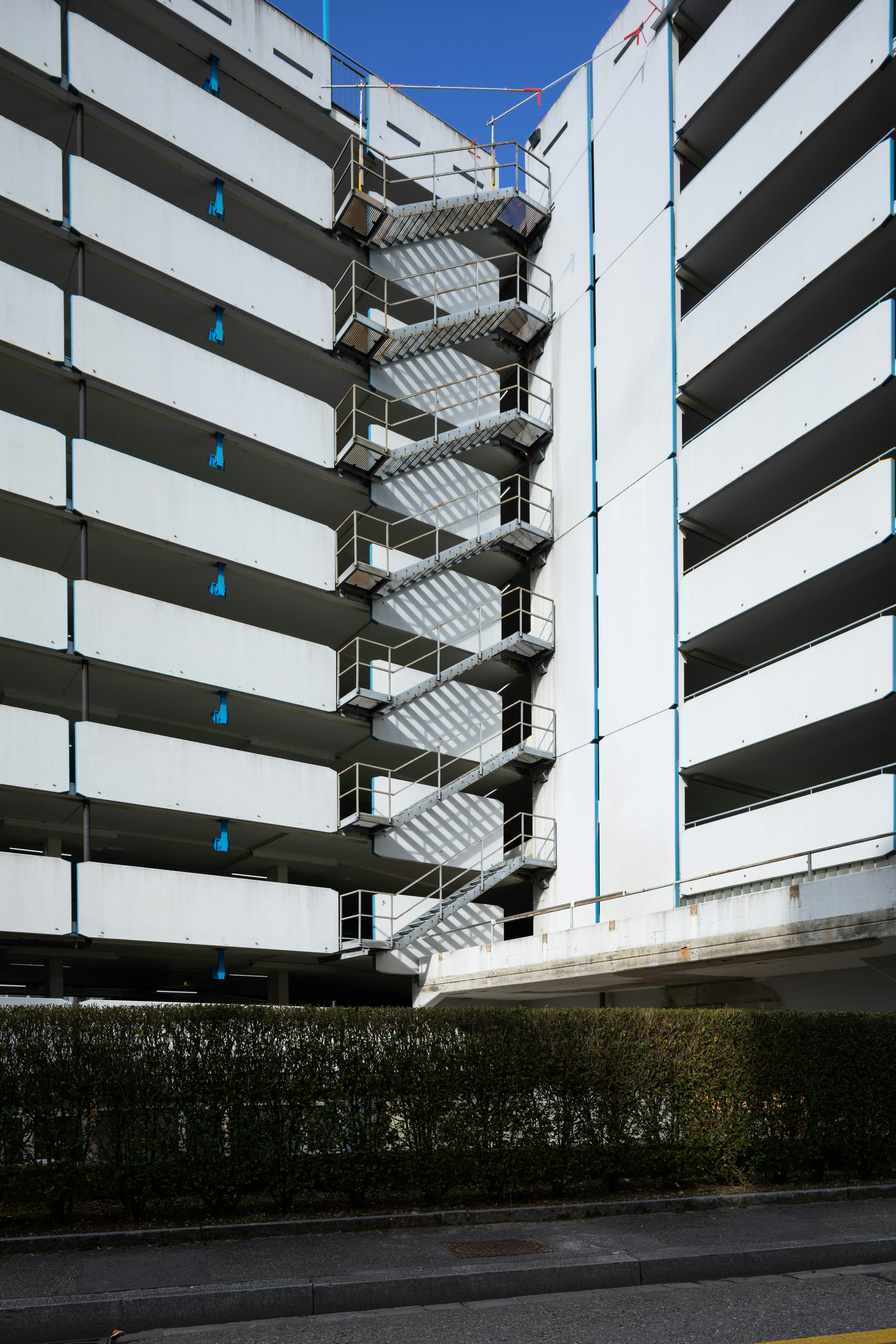 A tall white building with a spiral staircase next to it