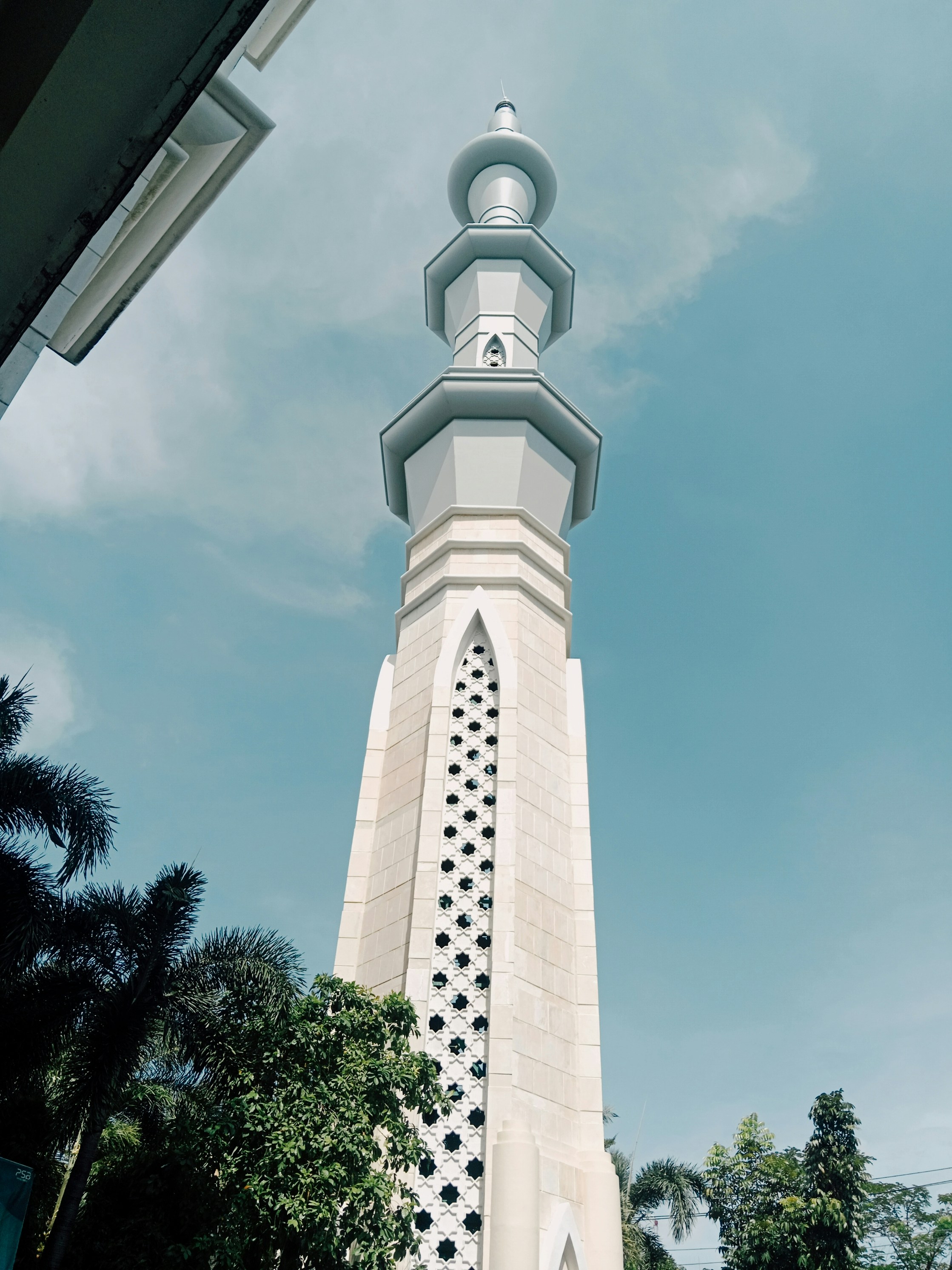 A tall white tower with a clock on it's side