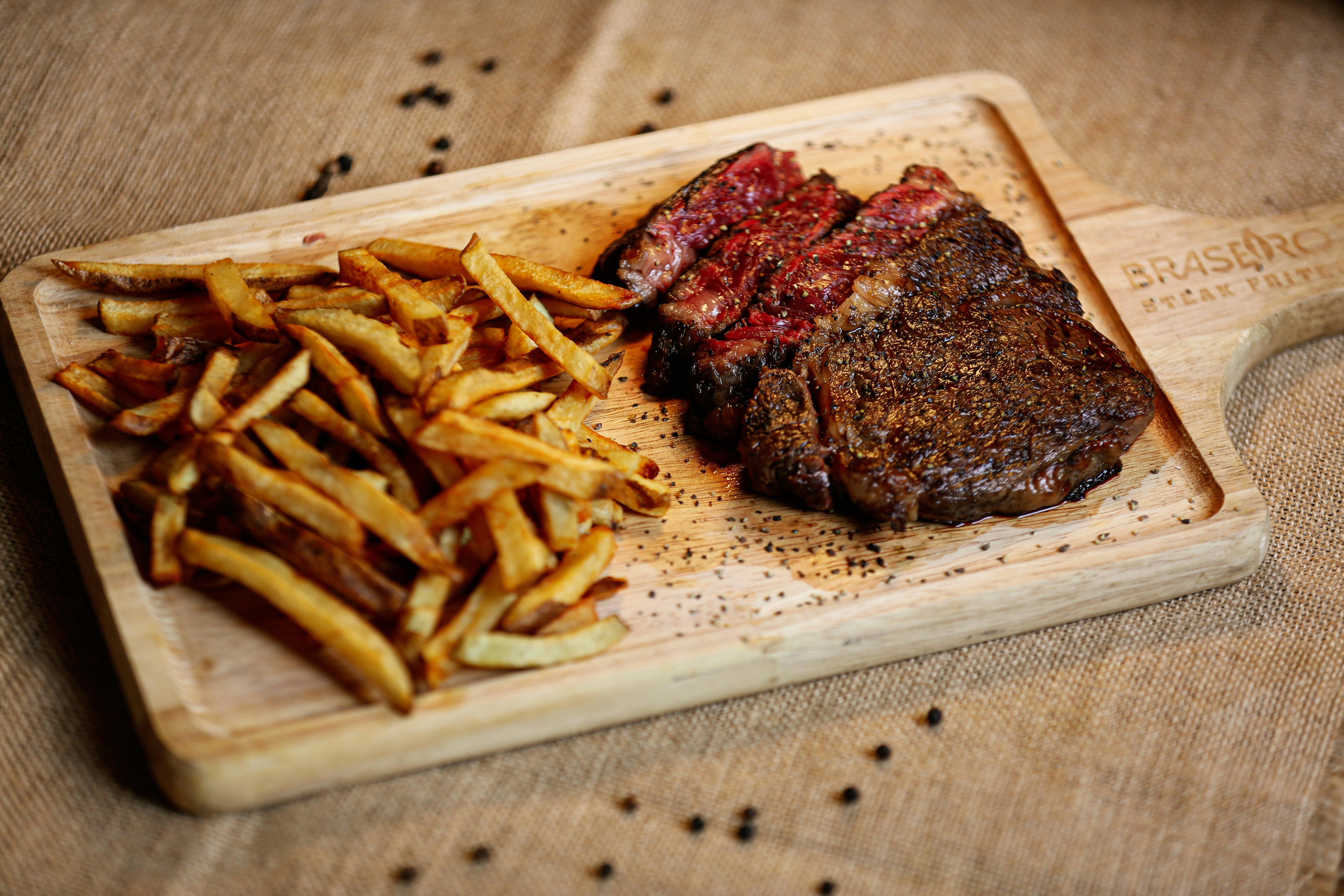 A steak and french fries on a cutting board, Our chef