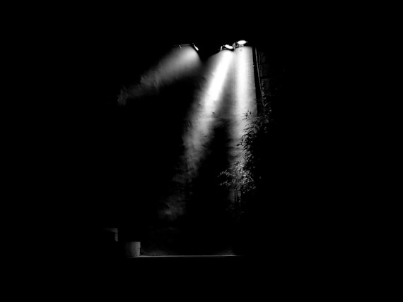 A black and white photo of a stage light