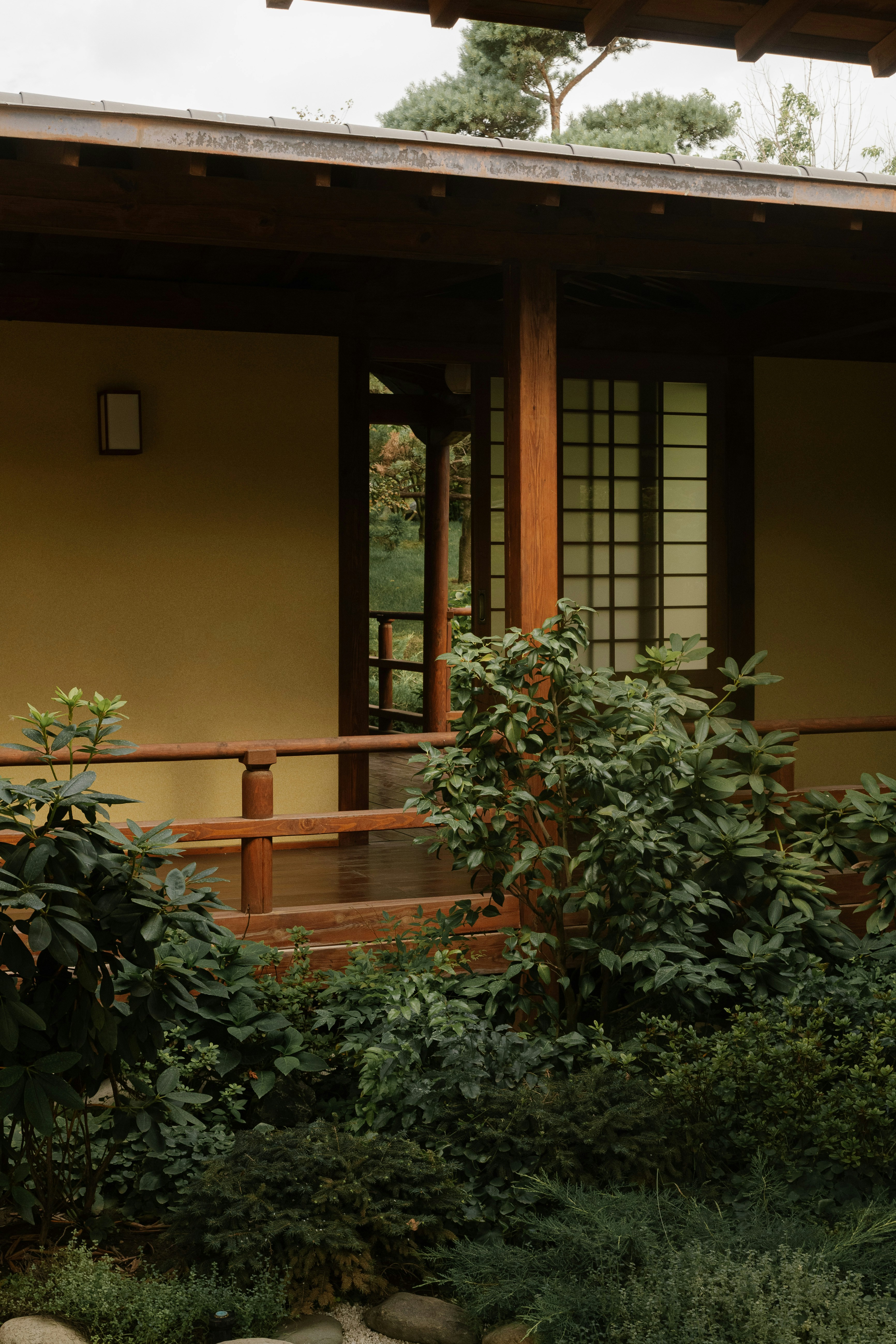 A yellow house with a wooden porch and wooden railing