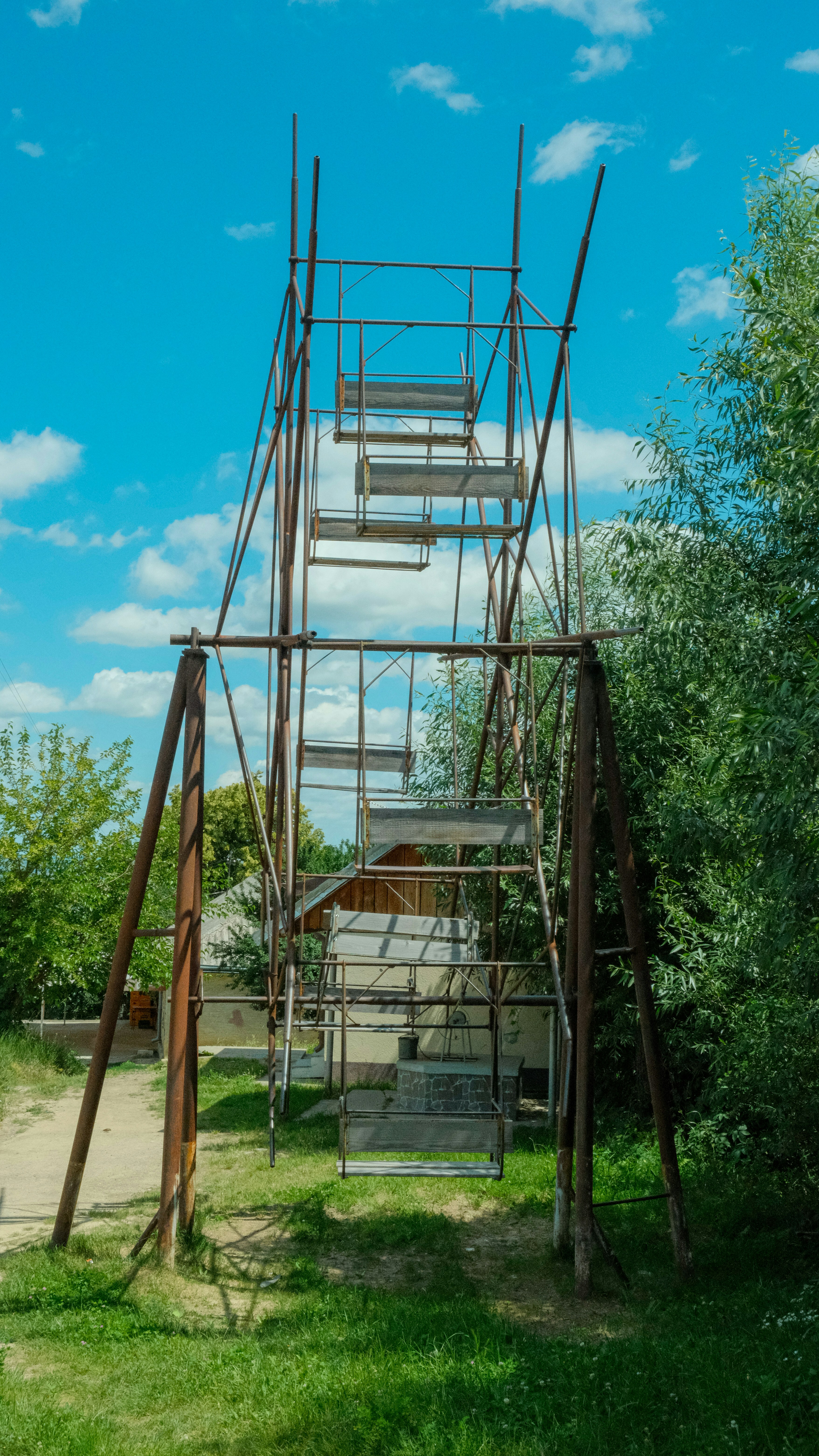 A tall metal structure sitting on top of a lush green field