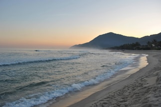 A sandy beach with waves coming in to the shore