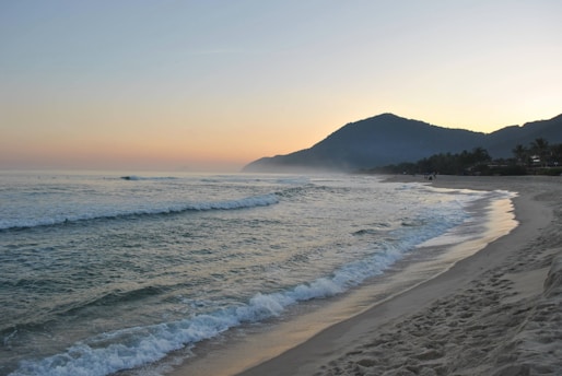 A sandy beach with waves coming in to the shore